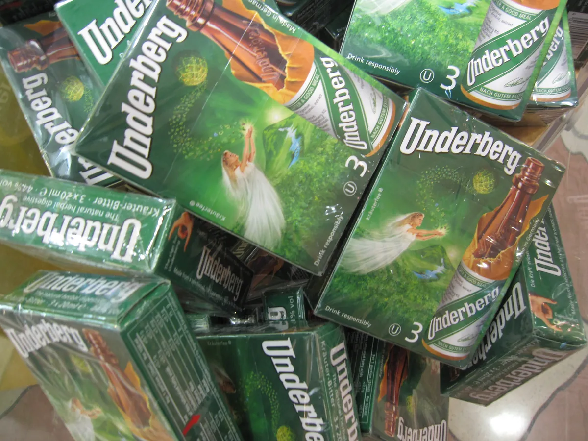 緑色の小瓶にオレンジのラベルが巻かれた Underberg の写真