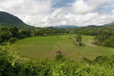 山に囲まれた谷間に水田と小屋が点在する農村風景